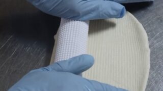 手でベーグル生地を成形している様子